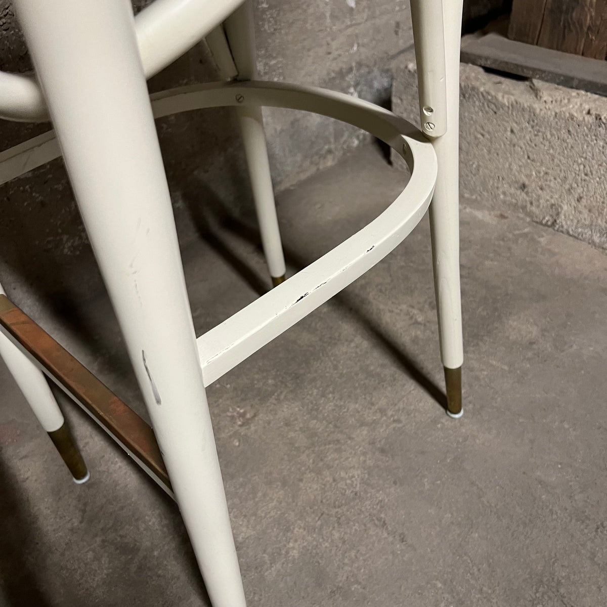 Off-white, mid-century bentwood barstools with upholstered seats and cane back rests.