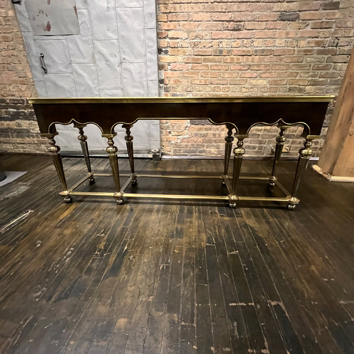 Lovely Hollywood Regency Console Table attributed to Mastercraft.  Burl wood top and apron with brass detail.  It sits on 8 brass legs with brass supports between the legs.  