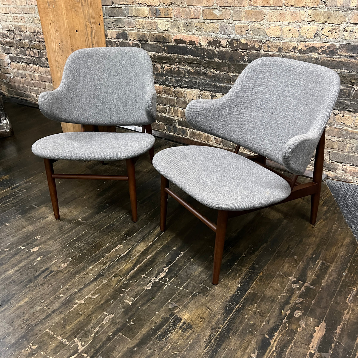 A pair of shell chairs with wood base and gray upholstery. Unmarked. Kofod-Larsen 