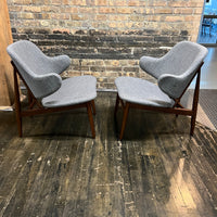 A pair of shell chairs with wood base and gray upholstery. Unmarked. Kofod-Larsen 